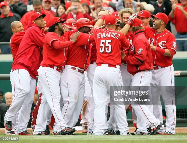 Joey Votto of the Cincinnati Reds is congratulated by teammates after a game winning hit in the bottom of the 9th inning during the game against the...