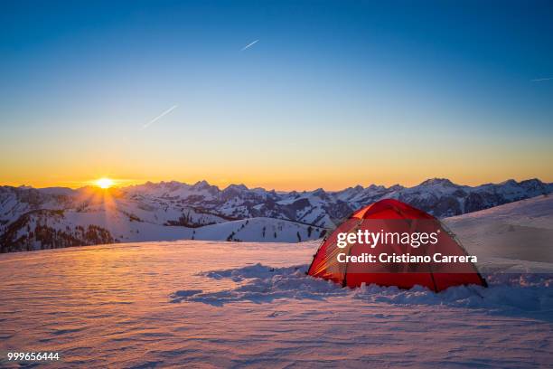 sunset with tent and snow mountains - cristiano imagens e fotografias de stock