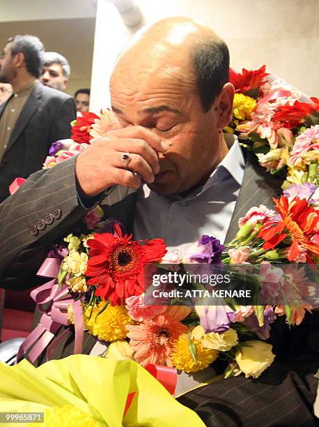 Iranian agent Ali Vakili Rad wipes his face as he arrives at Imam Khomeini Airport in Tehran, on May 18, 2010 after his release from a French where...