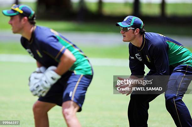 South African cricket team captain Graeme Smith and teammates AB de Villiers eye the ball to catch during a practice session at Sir Vivian Richards...