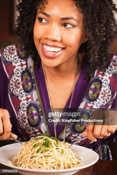 african american woman eating bowl of pasta - los angeles no kid hungry dinner stock pictures, royalty-free photos & images