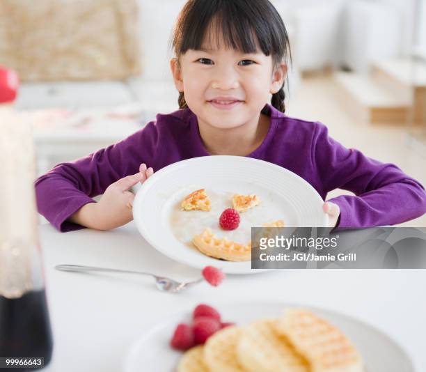 chinese girl making a face on plate with waffle - jgi jamie grill stock pictures, royalty-free photos & images