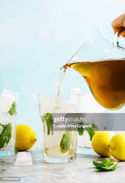 pour from pitcher traditional iced tea with lemon and ice in tal - tal stock pictures, royalty-free photos & images