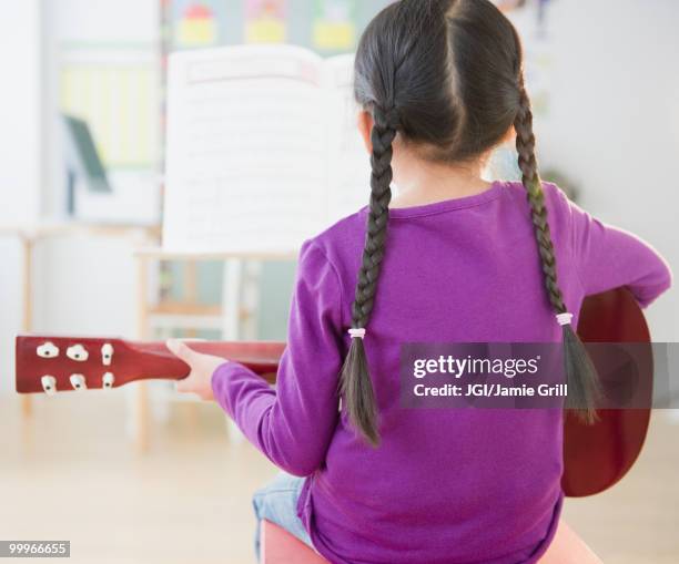 chinese girl playing guitar - jgi jamie grill stock pictures, royalty-free photos & images