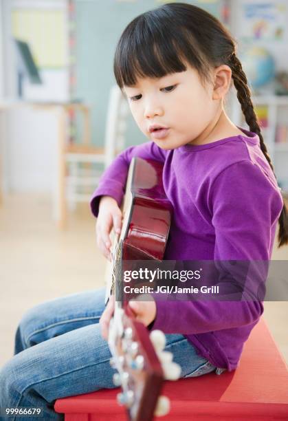 chinese girl playing guitar - jgi jamie grill stock pictures, royalty-free photos & images