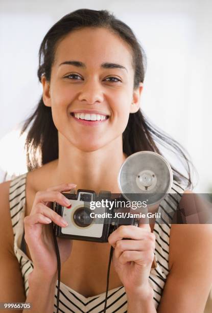 mixed race woman holding old-fashioned camera - jgi jamie grill stock pictures, royalty-free photos & images