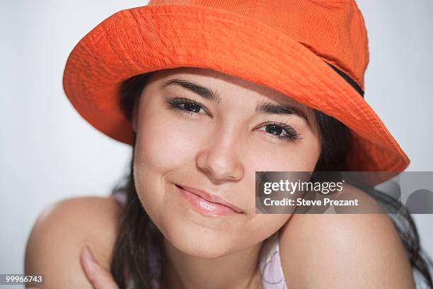 smiling hispanic woman in orange hat - steve prezant stock pictures, royalty-free photos & images