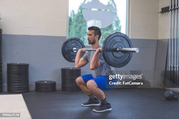 ethnische männlich hebt gewichte in einem fitnessstudio - raketentriebwerk stock-fotos und bilder