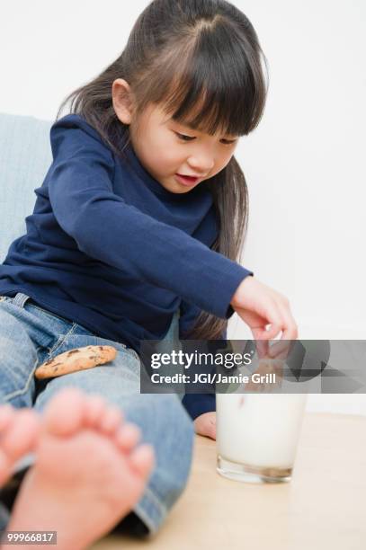 chinese girl dunking cookies in milk - jgi jamie grill stock pictures, royalty-free photos & images