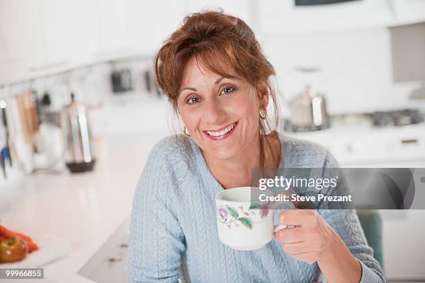 caucasian woman drinking coffee in kitchen - steve prezant stock pictures, royalty-free photos & images