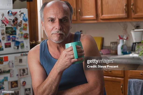 serious caucasian man drinking coffee in kitchen - steve prezant stock pictures, royalty-free photos & images