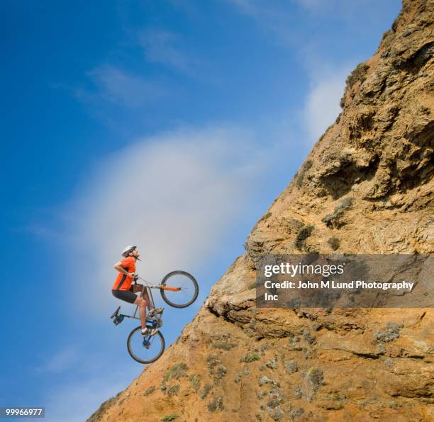 african man riding bicycle up steep hill - extreme sports bike stock pictures, royalty-free photos & images