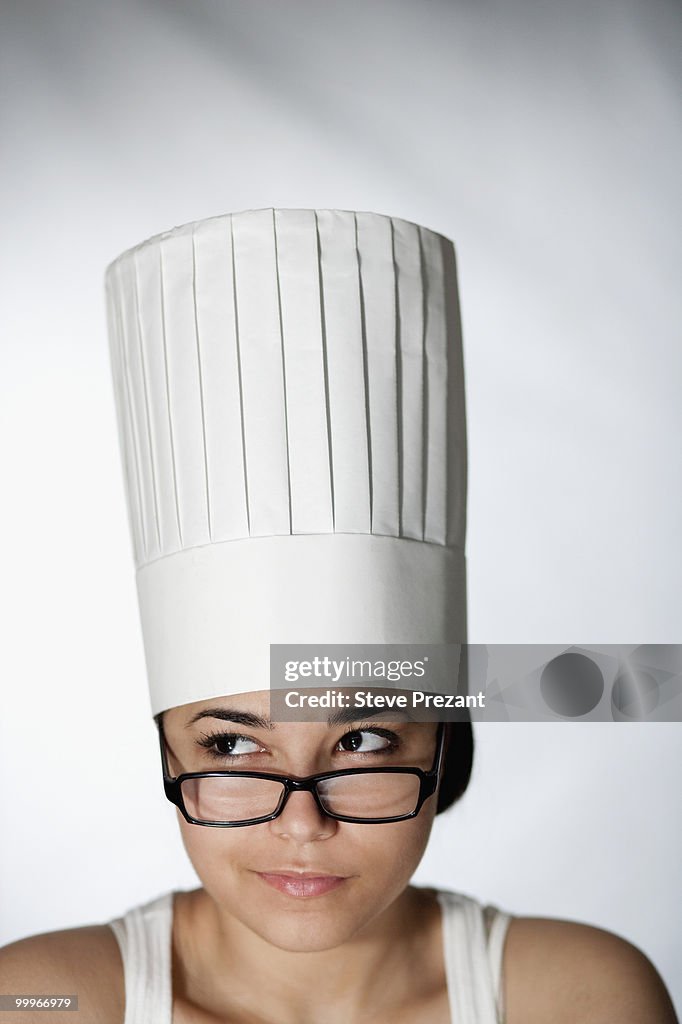 Hispanic woman in chef's hat and eyeglasses