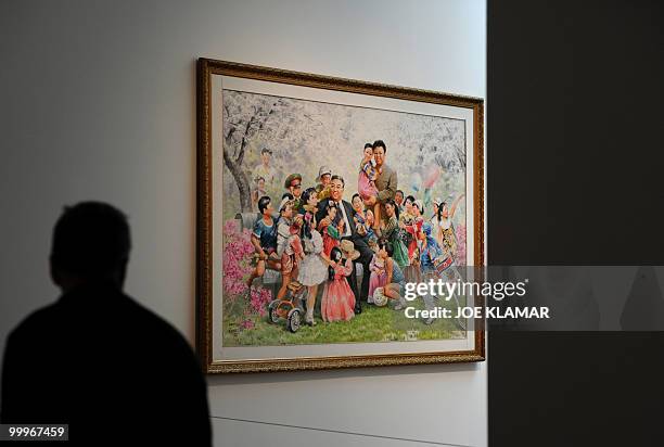 Visitor views a painting featuring North Korean leaders Kim Jong Il and his father Kim II Sung on display during the opening of of Democratic...