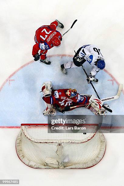 Jussi Jokinen of Finland is challenged by Vitaly Atyushov and goaltender Semyon Varlamov of Russia during the IIHF World Championship qualification...