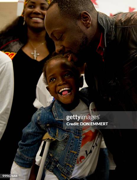 Musician Wyclef Jean greets 8-year-old Farah Maurice, who lost her leg above the knee as a result of the earthquake and who is visiting the US to...