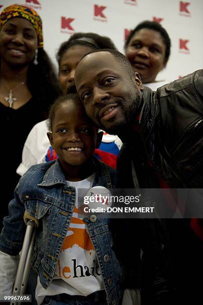 Musician Wyclef Jean greets 8-year-old Farah Maurice, who lost her leg above the knee as a result of the earthquake and who is visiting the US to...