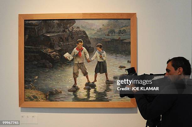 Cameraman shoots at a painting featuring North Korean schoolchildren being shown as part of the opening of the Democratic People's republic of North...