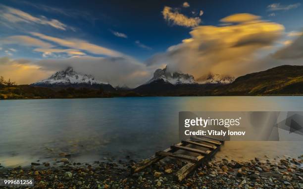 view of the mountains and the lake during the sunrise of torres del paine national park. autumn... - torres stock pictures, royalty-free photos & images
