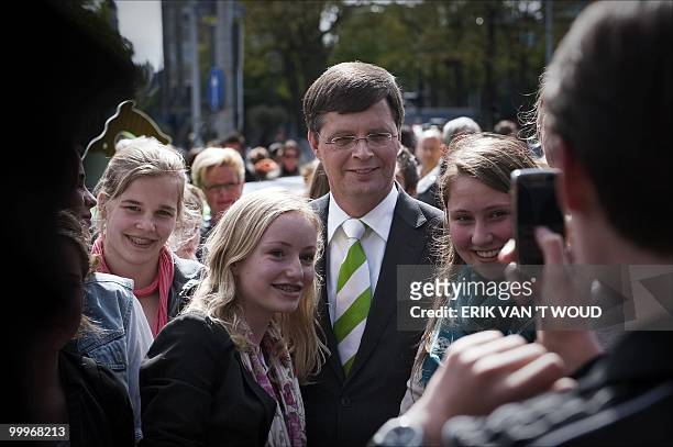 Outgoing Dutch Prime Minister Jan Peter Balkenende and leader of the Dutch Christian Democrats CDA is flanked by young supporters as one of their...