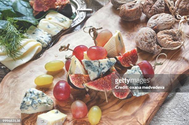 italian focaccia bread with cheese and a cheese plate with figs and gorgonzola, brie, dorblu and... - medvedeva ストックフォトと画像