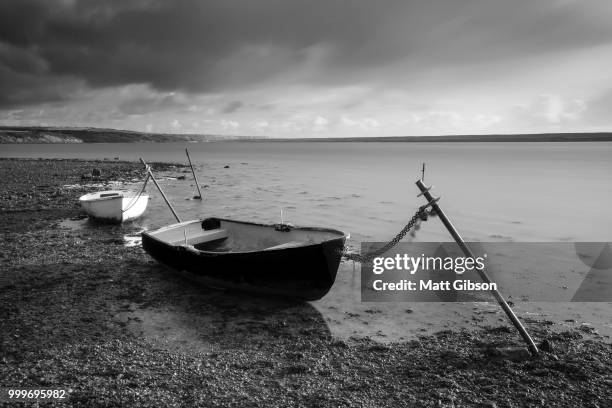beautiful black and white sunset landscape image of boats moored - lizardfish stock pictures, royalty-free photos & images