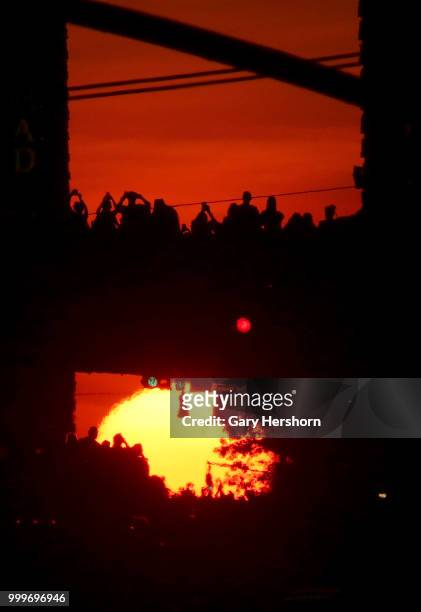 The setting sun moves across 42nd Street as people stand on the Pershing Square Bridge on Park Avenue during Manhattanhenge on July 13, 2018 in New...