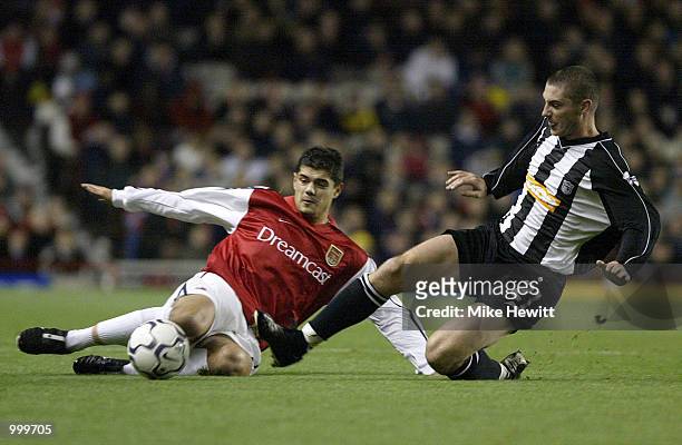 Phil Jevons of Grimsby slides into challenge Stathis Tavlaridis of Arsenal during the Worthington Cup Fourth Round match between Arsenal and Grimsby...