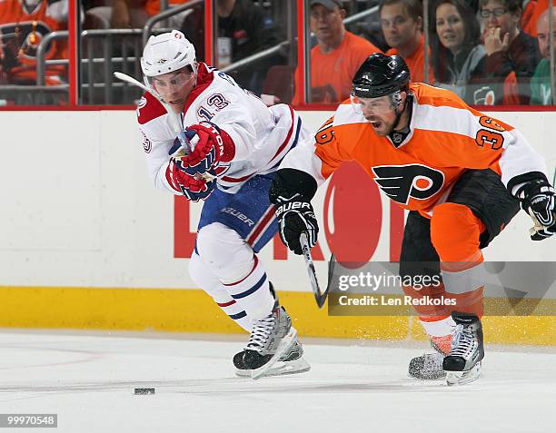 Darroll Powe of the Philadelphia Flyers chases after the loose puck with Michael Cammalleri of the Montreal Canadiens in Game Two of the Eastern...