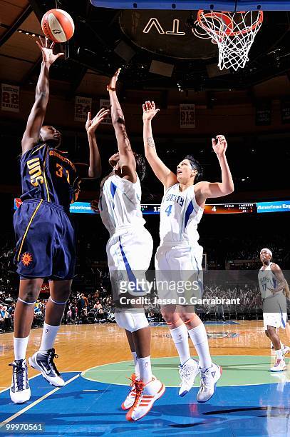 Tina Charles of the Connecticut Sun puts a shot up over Taj McWilliams-Franklin and Janel McCarville of the New York Liberty during the WNBA...