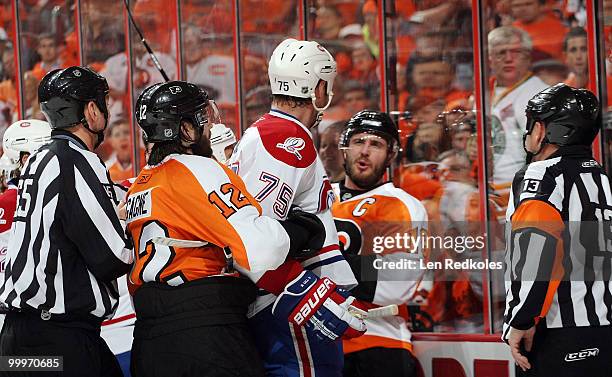 Hal Gill of the Montreal Canadiens is restrained by Simon Gagne of the Philadelphia Flyers from going after teammate Mike Richards in Game Two of the...