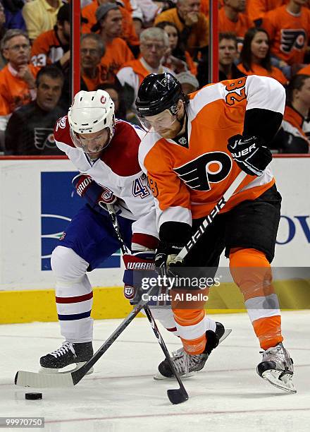 Dominic Moore of the Montreal Canadiens fights for the puck against Claude Giroux of the Philadelphia Flyers in Game 2 of the Eastern Conference...