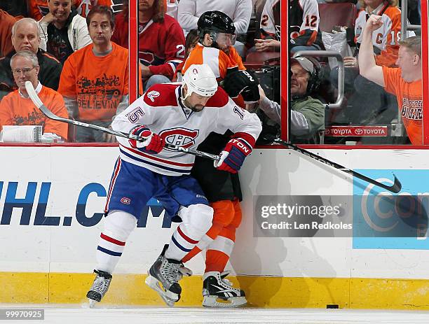 Glen Metropolit of the Montreal Canadiens pins Ville Leino of the Philadelphia Flyers to the boards as they battle for the loose puck in Game Two of...