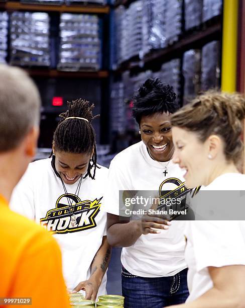 Shavonte Zellous and Olayinka Sanni of the Tulsa Shock volunteer at the Community Food Bank of Eastern Oklahoma on May 13, 2010 in Tulsa, Oklahoma....