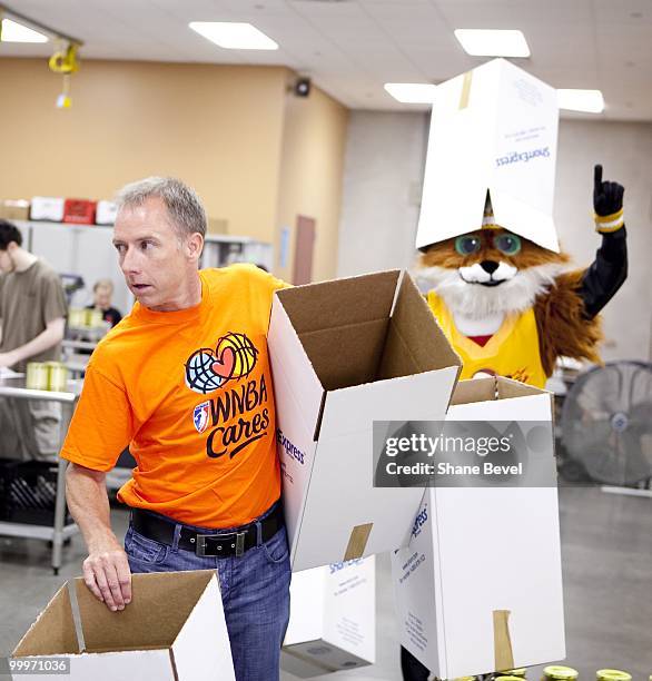 Owner David Box and mascot Volt of the Tulsa Shock volunteer at the Community Food Bank of Eastern Oklahoma on May 13, 2010 in Tulsa, Oklahoma. NOTE...