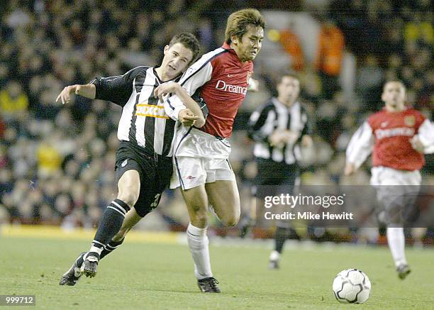 Junichi Inamoto of Arsenal holds off the challenge of Michael Boulding of Grimsby during the Worthington Cup Fourth Round match between Arsenal and...