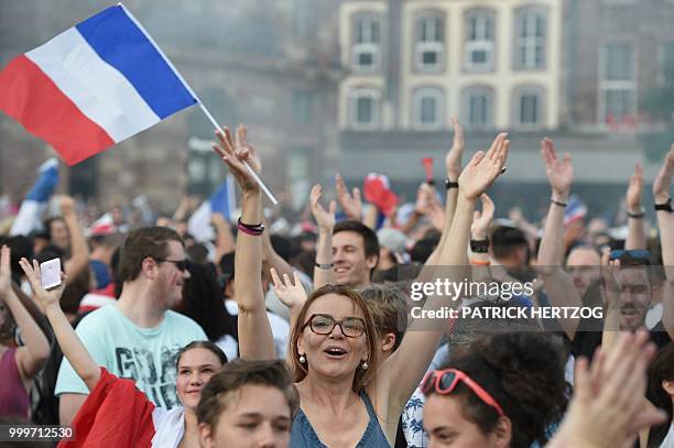 Peopler wave French national flags as they celebrate after France won the Russia 2018 World Cup final football match between France and Croatia, on...
