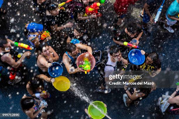 Revelers take part in the annual water fight known as "Batalla Naval" in Vallecas neighborhood, where thousands of people gathered to play with water.