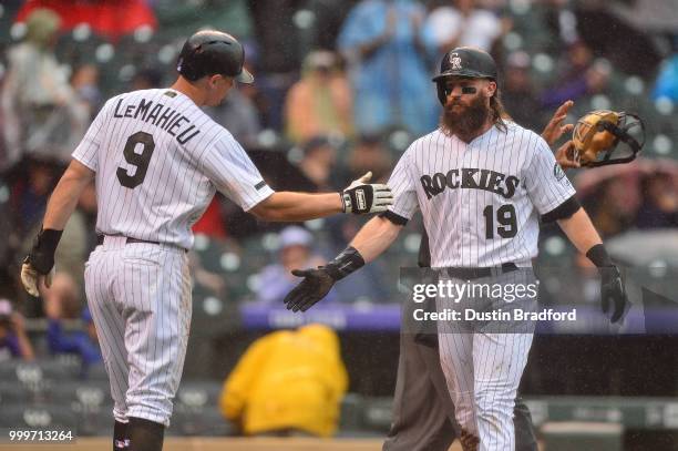 LeMahieu and Charlie Blackmon of the Colorado Rockies celebrate a pair of third inning runs scored against the Seattle Mariners at Coors Field on...