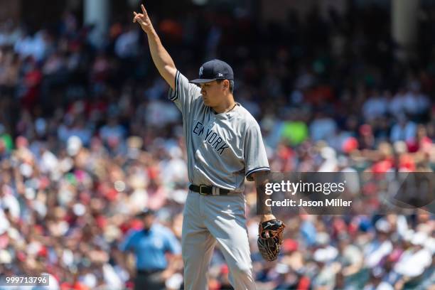 Starting pitcher Masahiro Tanaka of the New York Yankees signals to the outfield after Michael Brantley of the Cleveland Indians lined out to left...