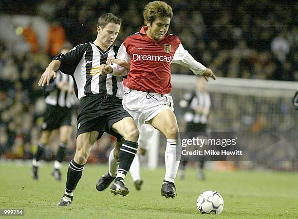 Junichi Inamoto of Arsenal holds off the challenge of Michael Boulding of Grimsby during the Worthington Cup Fourth Round match between Arsenal and...