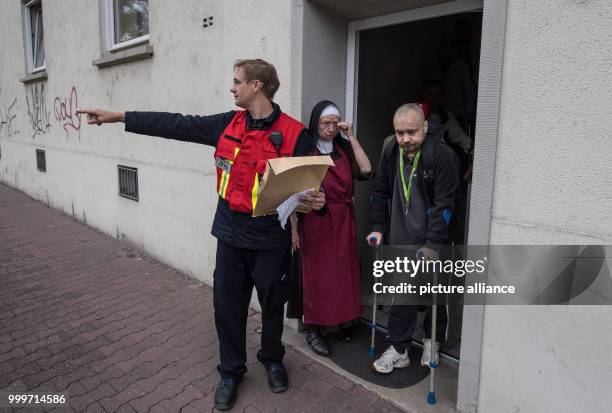 Sister Sigried from the nursing home "Haus Lichtblick" and a member of the fire department coordinate the route out of the restricted zone for...