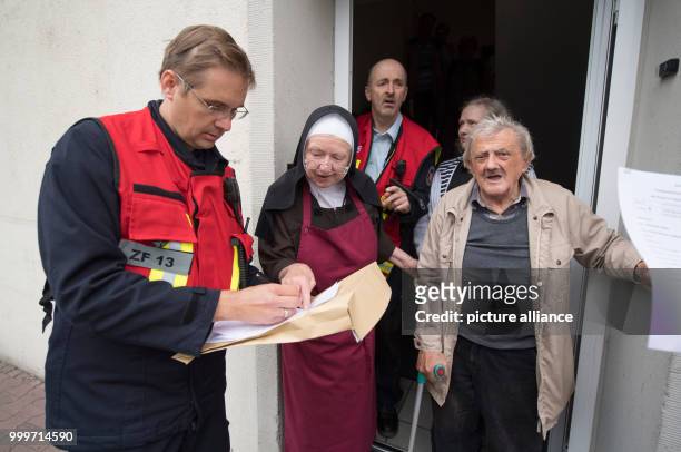 Sister Sigried from the nursing home "Haus Lichtblick" and a member of the fire department coordinate the route out of the restricted zone for...