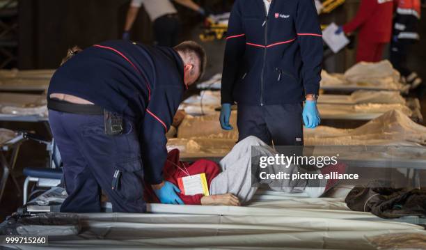 An elderly woman is helped onto a cot at the assembly centre at the Jahrhunderthalle, where numerous residents of nursing homes will spend the day in...