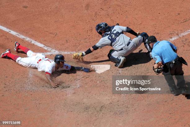 Cleveland Indians third baseman Jose Ramirez slides into home safely ahead of the tag of New York Yankees catcher Kyle Higashioka on a sacrifice fly...