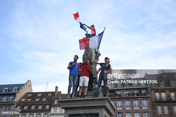 People wave French national flags as they celebrate after France won the Russia 2018 World Cup final football match between France and Croatia, on...