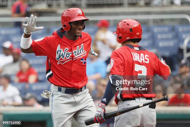 Seuly Matias of the Kansas City Royals and the World Team celebrates with teammate Leody Taveras of the Texas Rangers and the World Team after after...