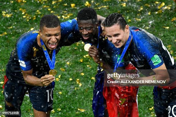 France's forward Kylian Mbappe, France's forward Ousmane Dembele and France's forward Florian Thauvin pose with their medals as they celebrate during...