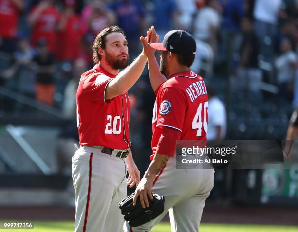 Daniel Murphy and Kelvin Herrera of the Washington Nationals celebrate a 6-1 win against the New York Mets during their game at Citi Field on July...