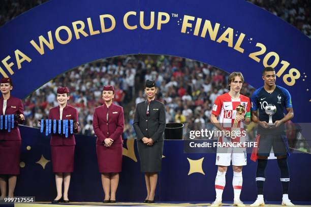 France's forward Kylian Mbappe poses with the FIFA Young Player award beside Croatia's midfielder Luka Modric holding the adidas Golden Ball prize...